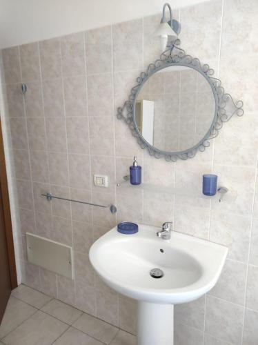 a bathroom with a white sink and a mirror at Casa Marina in Sestu