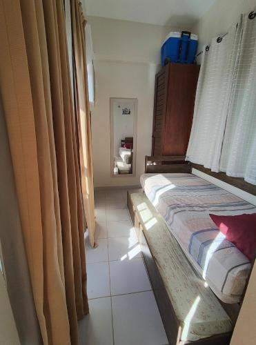 a small bedroom with a bed and a mirror at Paraiso do Atlantico Para 05 Hospedes in Salinópolis