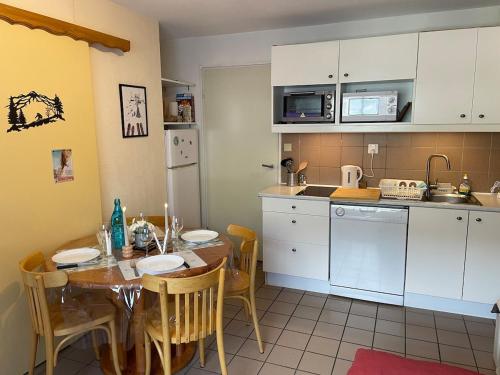 une cuisine avec une table et une salle à manger dans l'établissement Pieds des pistes Briançon Prorel - Serre Chevalier, à Briançon