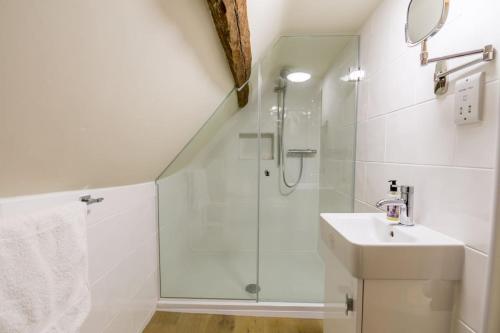 une salle de bain blanche avec une douche et un lavabo dans l'établissement Minster Loft, à York