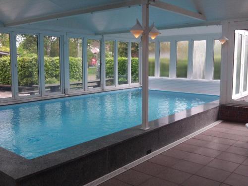 a large swimming pool in a house with windows at Ferienwohnung Wangerooge in Burhave in Butjadingen