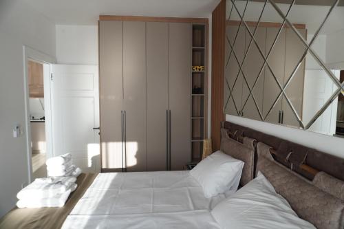 a bedroom with a large white bed with white pillows at Vienna Luxury Apartments in Dobra Voda