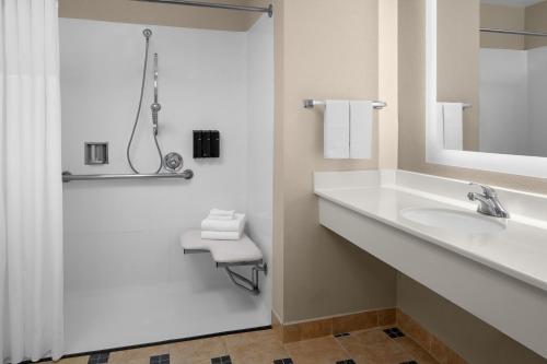 a white bathroom with a sink and a mirror at Larkspur Landing Extended Stay Suites Campbell in Campbell