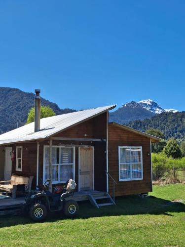 a small house with a car parked in front of it at Cabañas y tinaja El bus de chaqueihua in Hornopiren