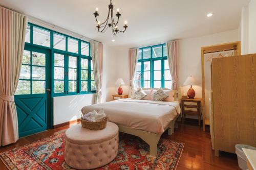 a bedroom with a bed and a large window at Summer Eternal Pool Villa Nimman in Chiang Mai
