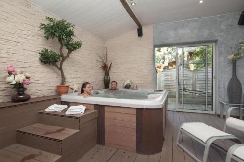two people in a bath tub in a room at MOBILHOME Soulac in Soulac-sur-Mer
