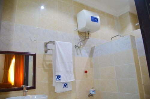 a bathroom with a towel dispenser and a sink at Residency Apartment and Hotel Guzape Hills Abuja in Abuja