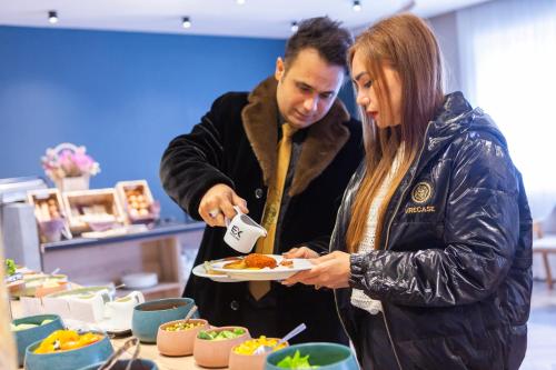 a man and a woman holding a plate of food at Expocore Hotel in Yerevan