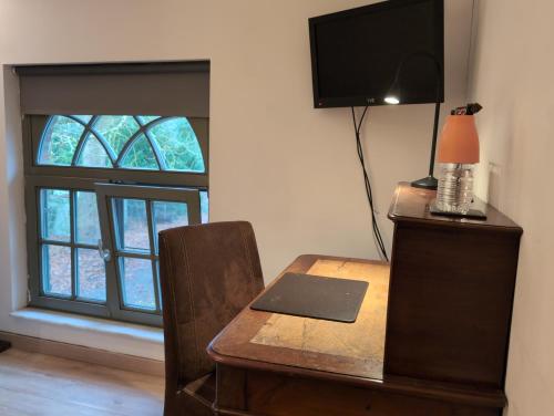 a desk with a laptop on top of it next to a window at Eremyten Hof in Evergem