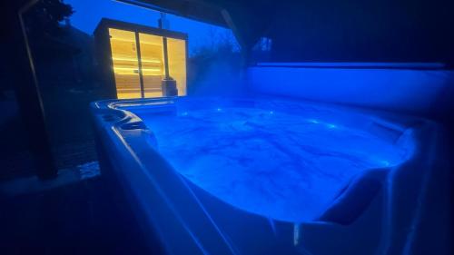 a bath tub in a room with a blue light at Balaton Apartman in Balatonmáriafürdő