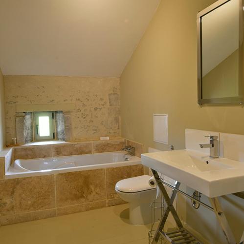 une salle de bain avec une baignoire, des toilettes et un lavabo dans l'établissement La Cannonerie, à Réaux