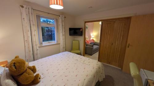 a teddy bear sitting on a bed in a bedroom at Willowdale B&B in Breakish