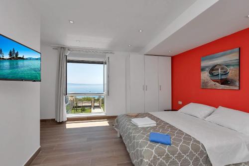 a bedroom with a large bed and a large window at Villa Infinite Joy in Makarska