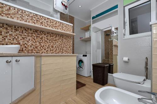 a bathroom with a sink and a washing machine at Villa Infinite Joy in Makarska