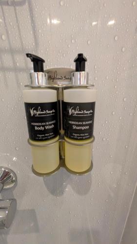 two bottles of moisturizers sitting on top of a sink at Willowdale B&B in Breakish