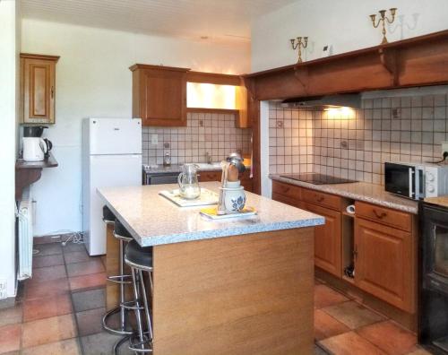 une cuisine avec des armoires en bois et un comptoir dans l'établissement Maison charmante à Nadillac avec piscine privée, à Saint-Cernin