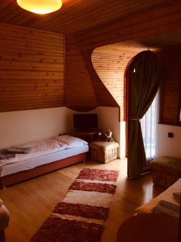 a bedroom with a bed and a tv in a room at Káptalan vendégház in Balatonalmádi