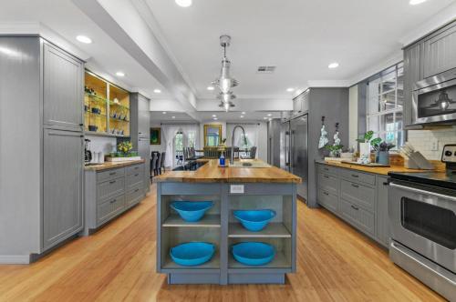 a large kitchen with a island with blue bowls on it at #1 Largest Tampa Private Compound 13BR Sleeps 40 Heated Pool Spa in Tampa
