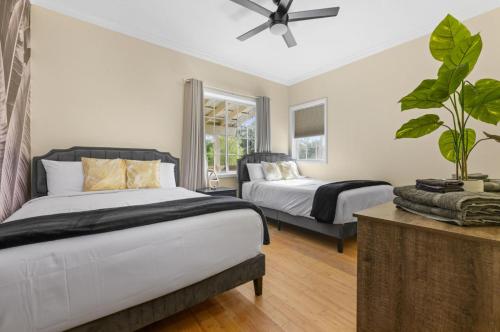 a bedroom with two beds and a ceiling fan at #1 Largest Tampa Private Compound 13BR Sleeps 40 Heated Pool Spa in Tampa