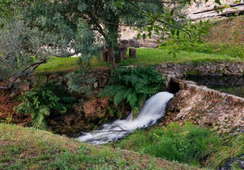 a stream of water coming out of a ditch at Peneda-Gerês - Nature Pool - Garden - Parking free in Sabadim