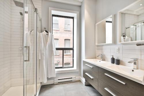 a bathroom with a shower and a sink and a window at Les Lofts du Mile End-Plateau Mont Royal in Montréal
