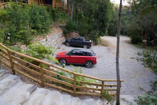 a red car and a black truck parked on a road at Agua de la piedra in Valdivia