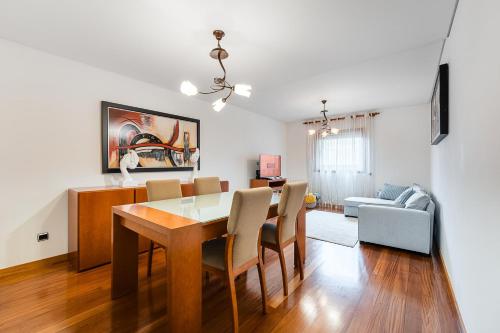 a dining room and living room with a table and chairs at Casa La Guardia at 5 minutes from the beach in Póvoa de Varzim