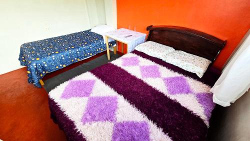 a bedroom with a bed and a purple and purple rug at Alojamiento en Puno in Puno