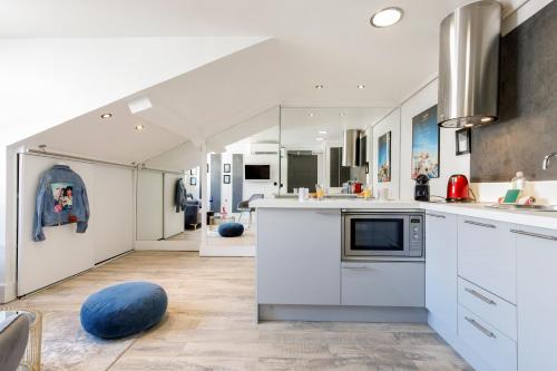 - une cuisine avec des placards blancs et une boule bleue au sol dans l'établissement Cosy & design à côté du Palais et des plages, à Cannes