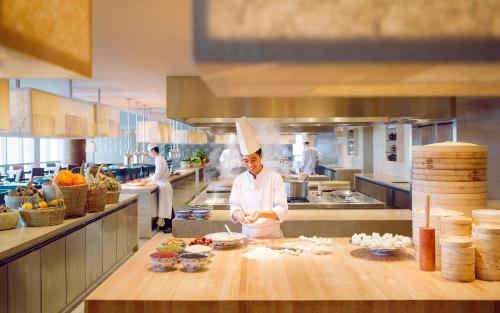 a chef preparing food in a large kitchen at Park Hyatt Guangzhou in Guangzhou