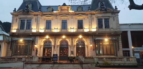 un grand bâtiment avec des lumières sur la façade dans l'établissement Studio Albizia Lamalou les Bains, à Lamalou-les-Bains