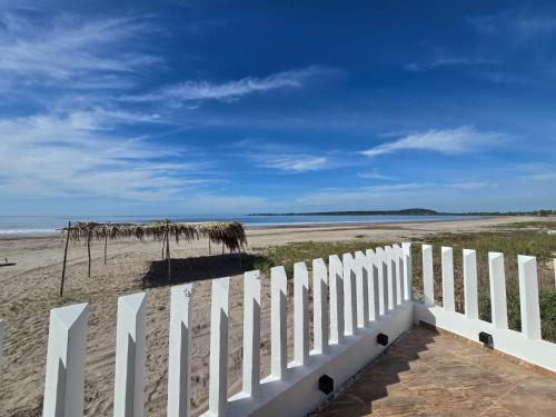 a white fence on the beach next to the ocean at Casa Xïri. Matanchén, San Blas. in San Blas