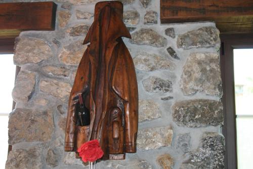 a wooden statue of a woman hanging on a stone wall at El Quesar de Gamoneo in Gamonedo de Cangas