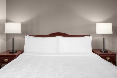 a large white bed with two lamps on both sides at Larkspur Landing Extended Stay Suites Hillsboro in Hillsboro