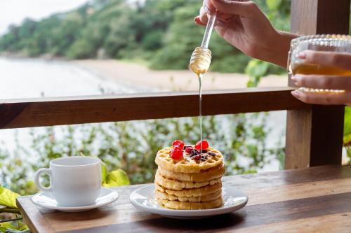 フロリアノポリスにあるGrandi Pousada Sports - Sambaquiのスプーンでケーキを食べている人