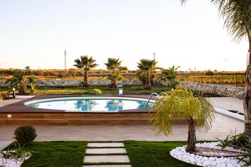 a swimming pool in a garden with palm trees at Villa Margares in Valenzano