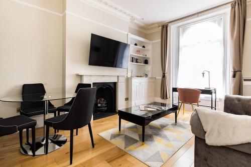 a living room with a table and a fireplace at Avari Apartments - Winchester Collection in London