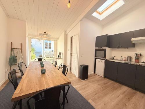 - une cuisine avec une table et des chaises en bois dans la chambre dans l'établissement Villa Joséphine Plage de Boyard, à Saint-Georges-dʼOléron