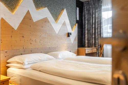 a bedroom with two beds and a wooden headboard at CHALET ARIA Stay Mountain Relax in Arabba