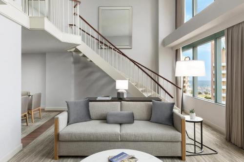 a living room with a couch and a staircase at The Westin Long Beach in Long Beach