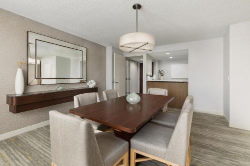 a dining room and living room with a table and chairs at The Westin Long Beach in Long Beach