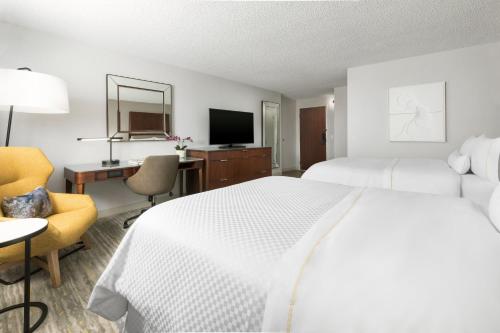 a hotel room with a bed and a desk and a television at The Westin Long Beach in Long Beach