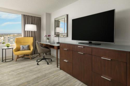 a hotel room with a television and a desk with a chair at The Westin Long Beach in Long Beach