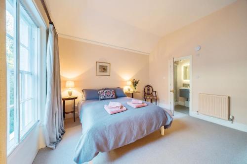 a bedroom with a bed and a large window at Artist's Studio in Piddlehinton