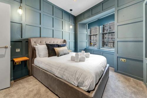 a bedroom with a large bed with blue walls at Warden's Close Apartments in Edinburgh
