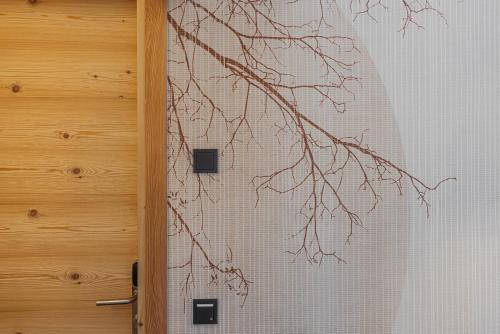 a door with a wall with a tree branch at CHALET ARIA Stay Mountain Relax in Arabba