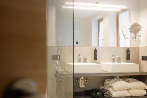a bathroom with two sinks and a mirror at CHALET ARIA Stay Mountain Relax in Arabba