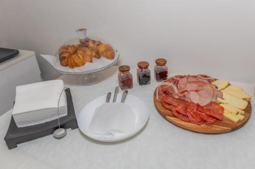 eine Theke mit einem Teller Essen und einem Teller Fleisch und Käse in der Unterkunft TiglioExperienceComo in Como