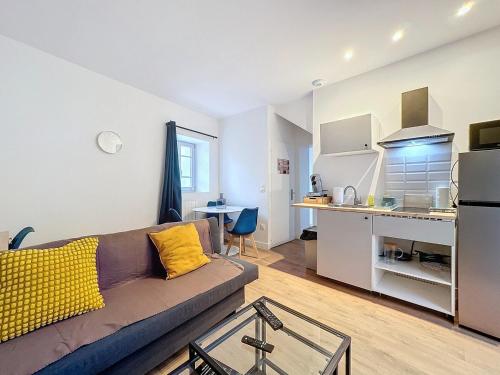 un salon avec un canapé et une cuisine dans l'établissement Appartement cosy près de la gare - 4 pers - Nr1, à Clermont-Ferrand