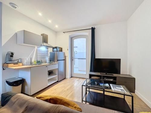 un salon avec un canapé et une cuisine dans l'établissement Appartement cosy près de la gare - 4 pers - Nr1, à Clermont-Ferrand